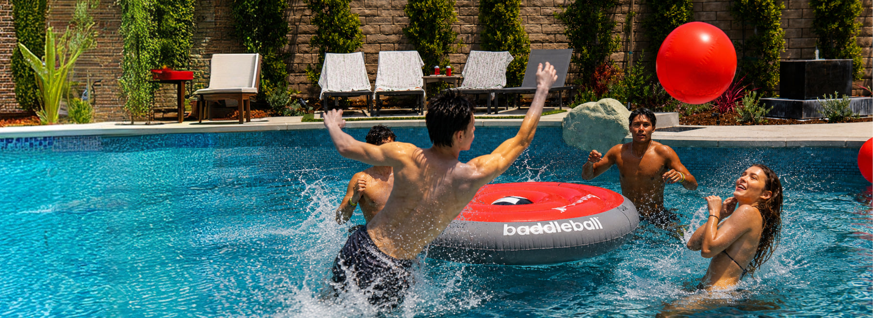 Four players rally around the baddleball board in a pool
